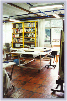 Ateliê de restauração com mesa técnica e biblioteca